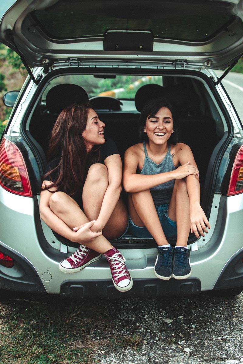 2 best friends smiling in a car