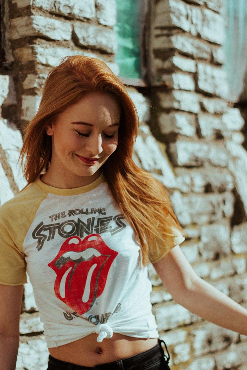 woman with rolling stones shirt smiling keeping a smile quotes