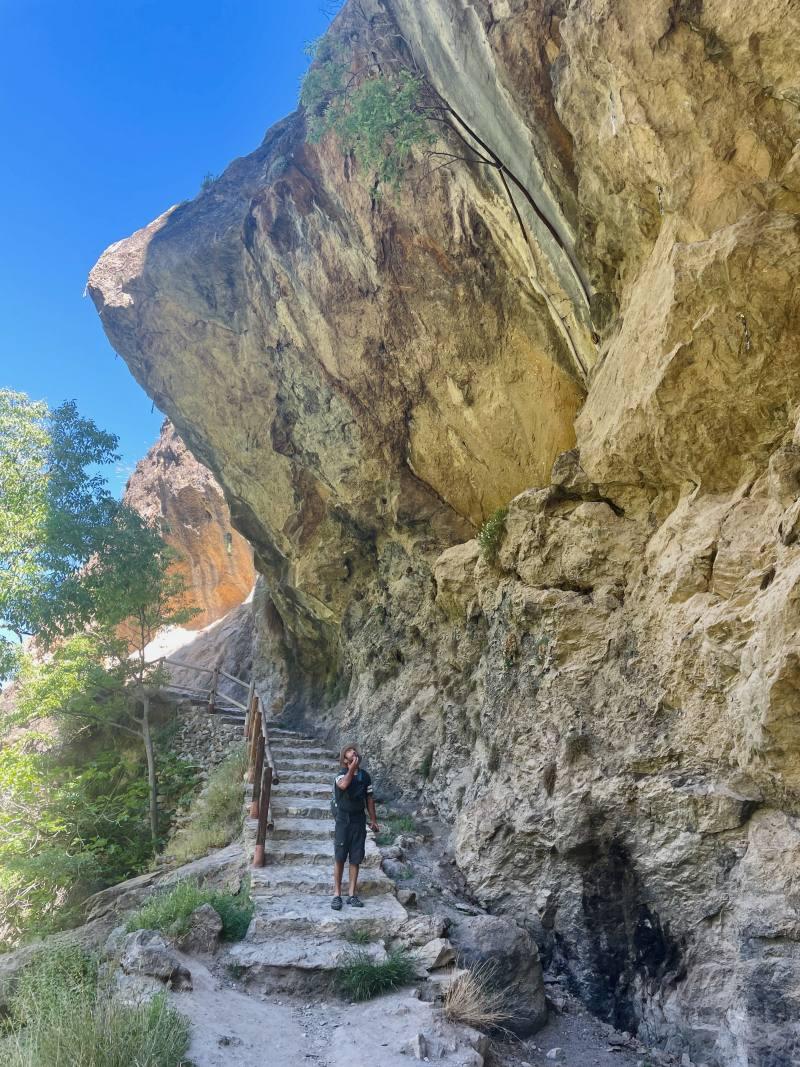 man looking at the huge rocky wall